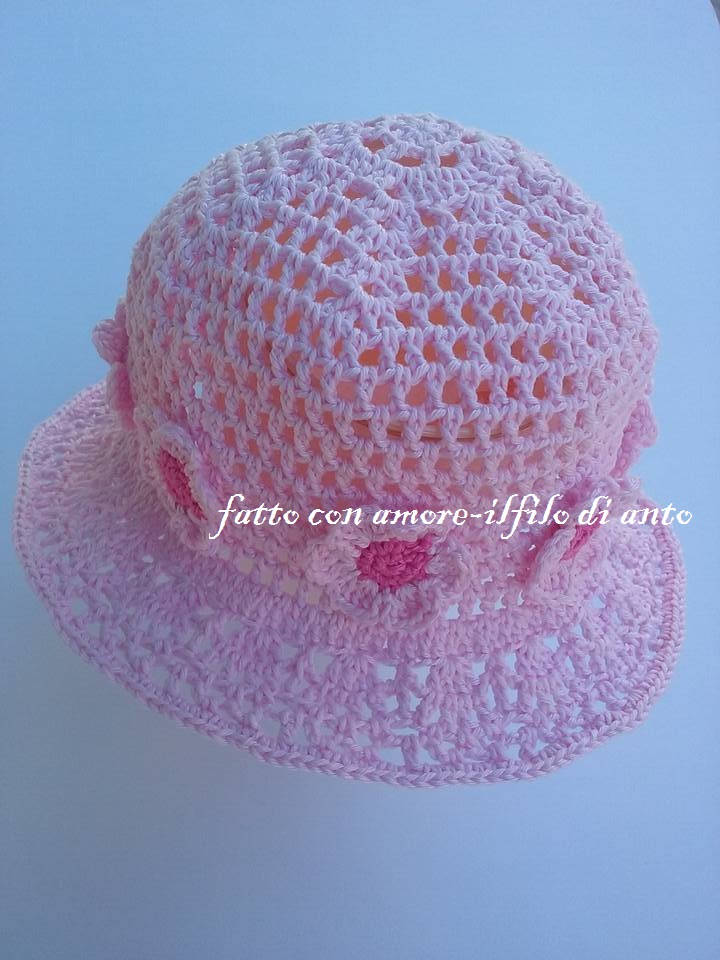 Cappello  rosa  traforato con tesa e  fiori bianchi